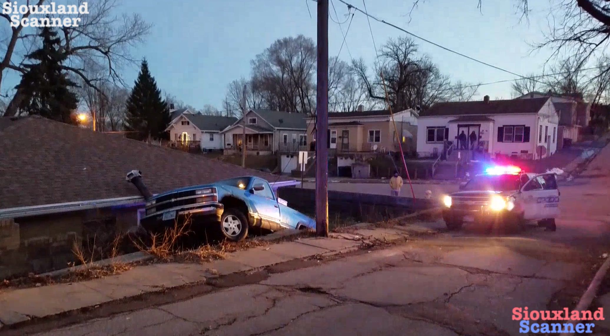 Truck ends up between home and retaining wall